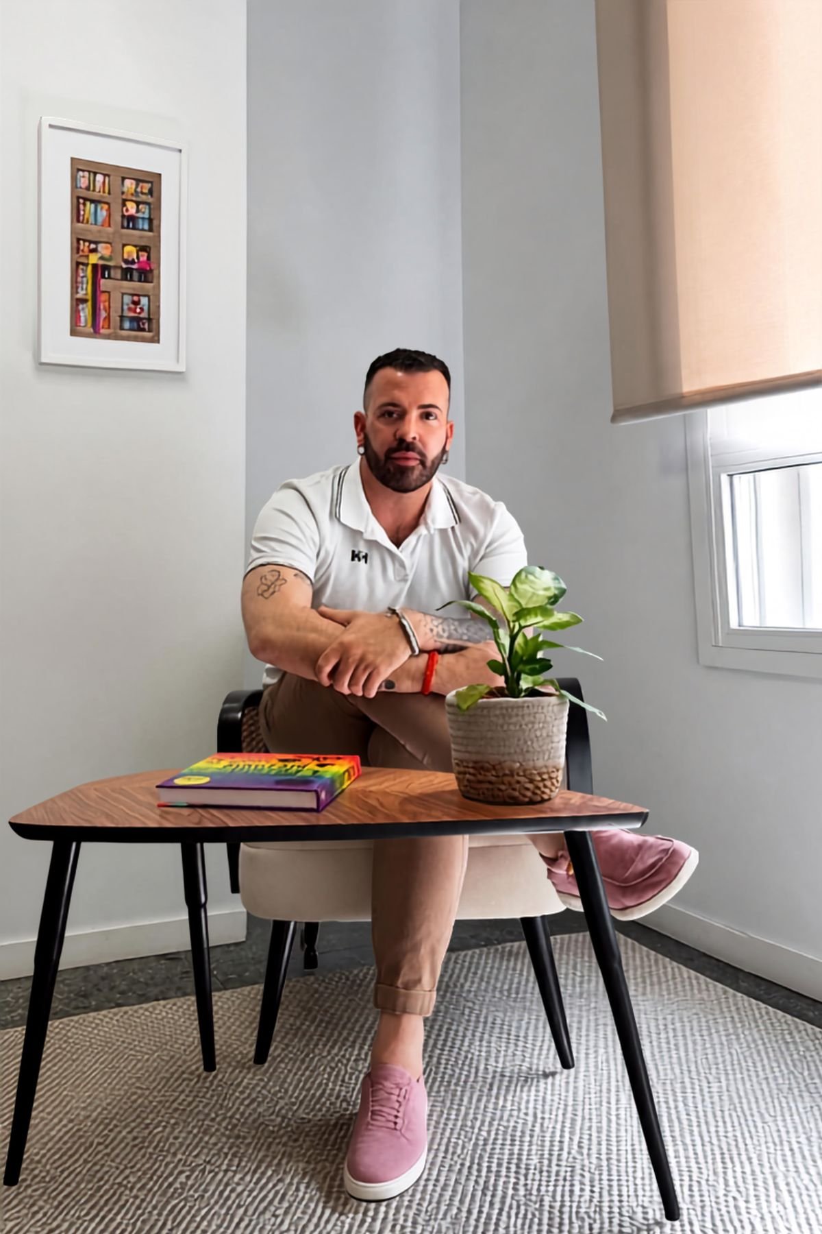 Fran Pardo sentado en el despacho, junto a una mesa con una planta y un libro