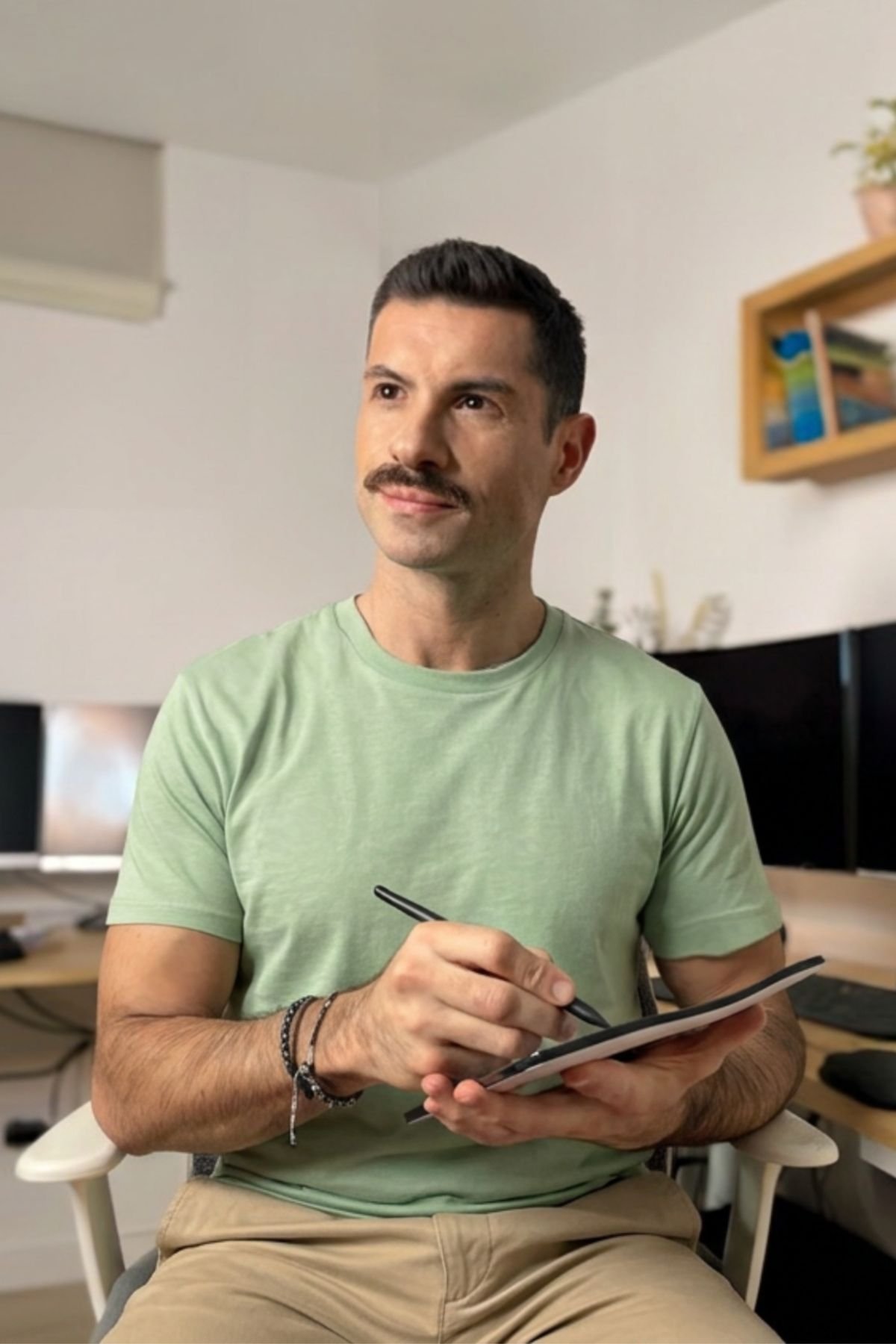 Pau Sanz sentado con una tableta y un lápiz digital en la mano, en un espacio de trabajo con luz natural